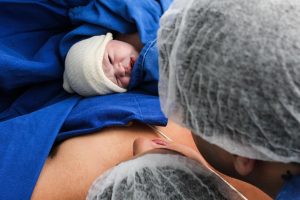 Newborn baby with mother in first week after birth, early breastfeeding stage